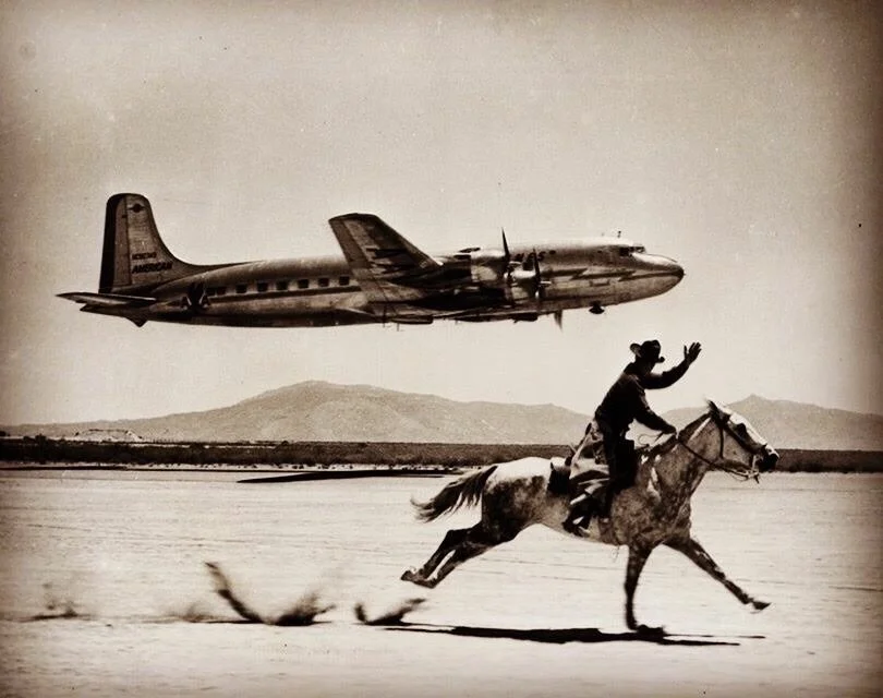 Man on a horse waving to a plane