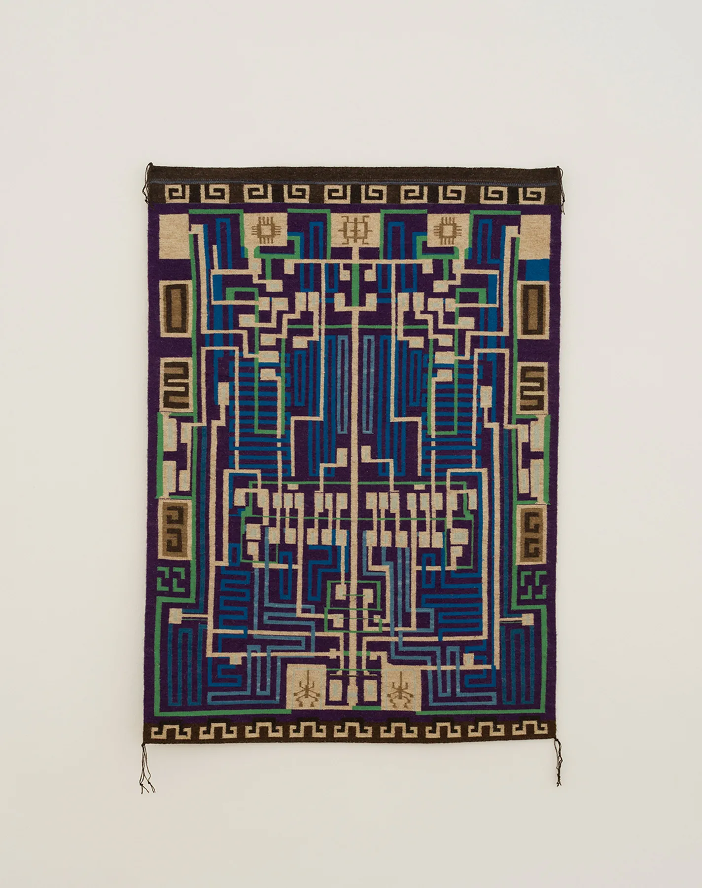 Navajo woven textile by Marilou Schultz, patterned like a computer chip; it echoes the article’s warning about AI’s double-edged cybersecurity impact.
